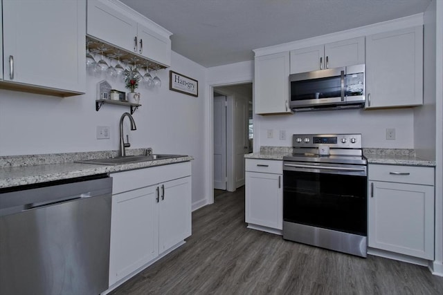 kitchen featuring appliances with stainless steel finishes, a sink, white cabinets, dark wood finished floors, and open shelves