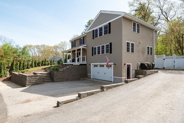 21 Molloy Rd, Georgetown, MA 01833 - view of home's exterior with asphalt driveway, an attached garage, stairs, fence, and a gate