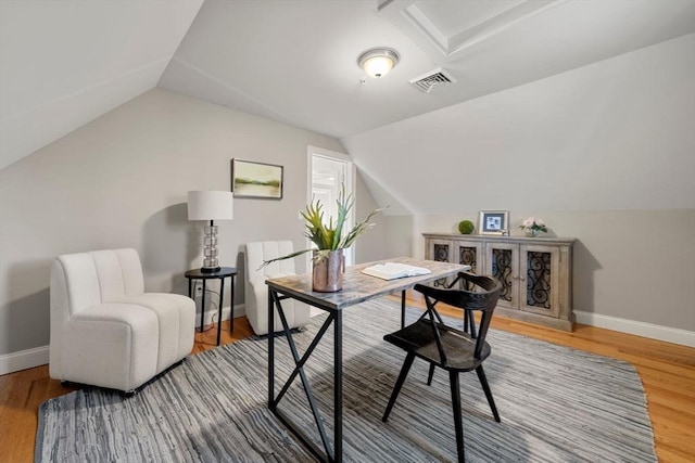 office space with lofted ceiling, wood finished floors, visible vents, and baseboards