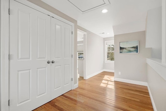 corridor with light wood finished floors and baseboards