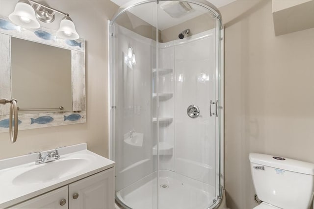 bathroom with a shower stall, toilet, and vanity