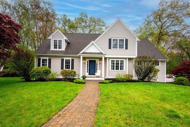 view of front facade featuring a front lawn and roof with shingles