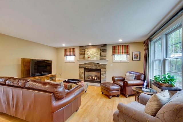 living room featuring a fireplace, light wood-style flooring, and recessed lighting