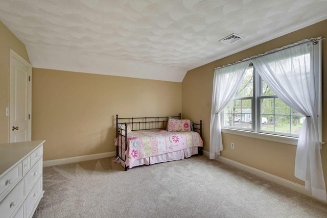 bedroom featuring vaulted ceiling, light carpet, baseboards, and a textured ceiling