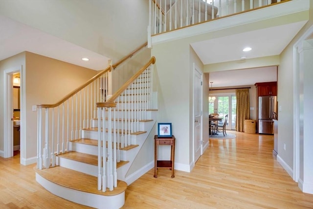 stairway featuring wood finished floors, baseboards, and recessed lighting