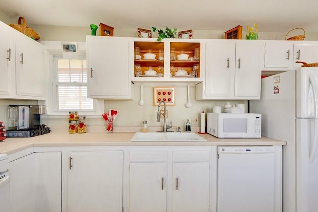 kitchen featuring white cabinetry, sink, and white appliances