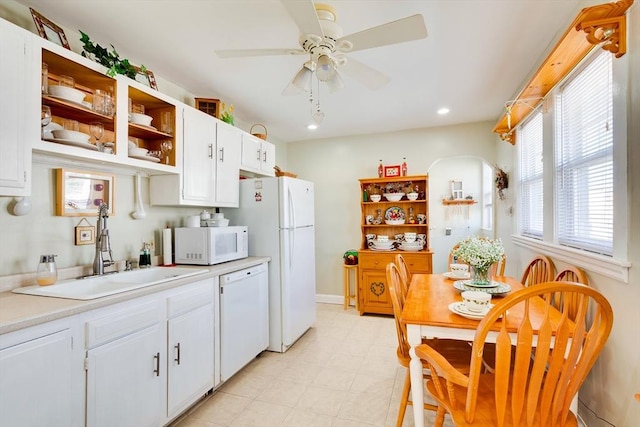 kitchen with sink, white appliances, white cabinets, and ceiling fan