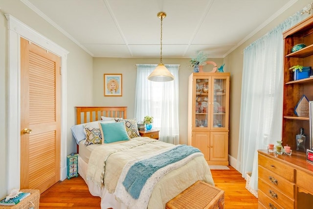 bedroom featuring crown molding and light hardwood / wood-style floors