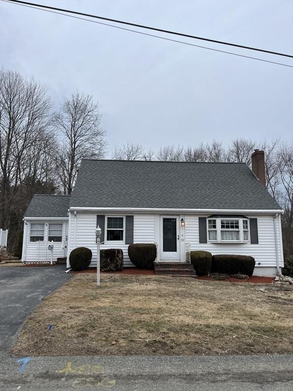 view of front of property with entry steps, driveway, a chimney, and roof with shingles