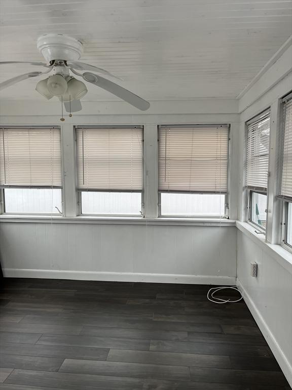 unfurnished sunroom with ceiling fan