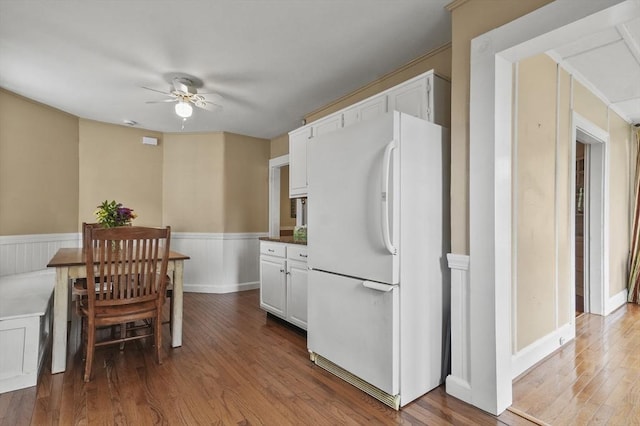 30 Wentworth Ave, Lowell, MA 01852 - kitchen featuring freestanding refrigerator, a ceiling fan, wood finished floors, a wainscoted wall, and white cabinetry