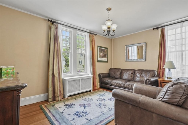 30 Wentworth Ave, Lowell, MA 01852 - living area featuring radiator, a chandelier, baseboards, ornamental molding, and wood finished floors