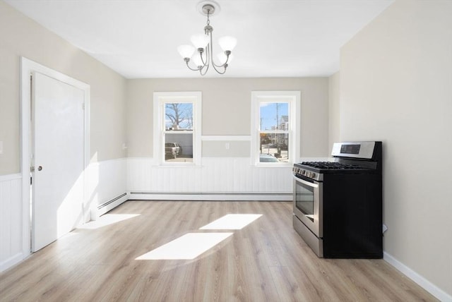 kitchen featuring a notable chandelier, a wainscoted wall, a baseboard heating unit, light wood-style floors, and gas range