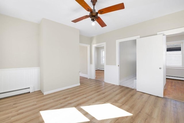 interior space featuring a baseboard radiator, a baseboard heating unit, wood finished floors, and wainscoting