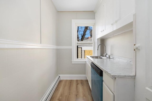 washroom with light wood-style floors, a baseboard radiator, baseboards, and a sink