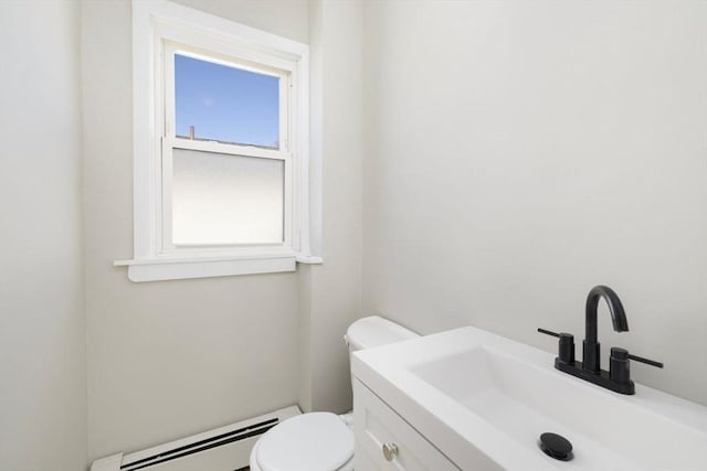 half bath featuring a baseboard heating unit, vanity, and toilet