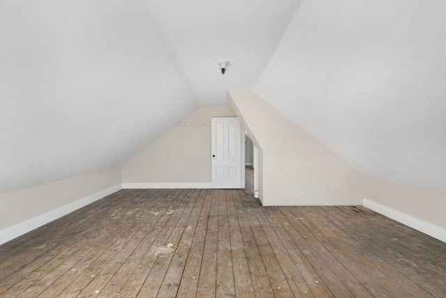 bonus room with lofted ceiling, hardwood / wood-style floors, and baseboards