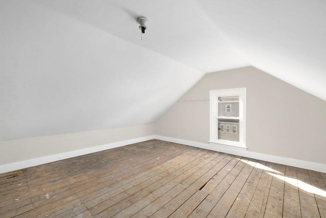 bonus room featuring baseboards, vaulted ceiling, and hardwood / wood-style floors