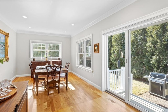 dining space featuring baseboards, light wood-style floors, and ornamental molding