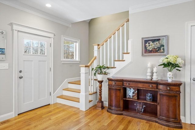 entryway featuring baseboards, light wood-style flooring, stairs, and ornamental molding