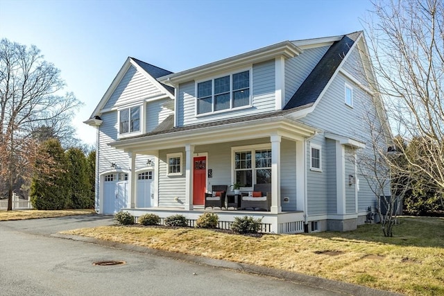 view of front of house with aphalt driveway, a front lawn, covered porch, and an attached garage