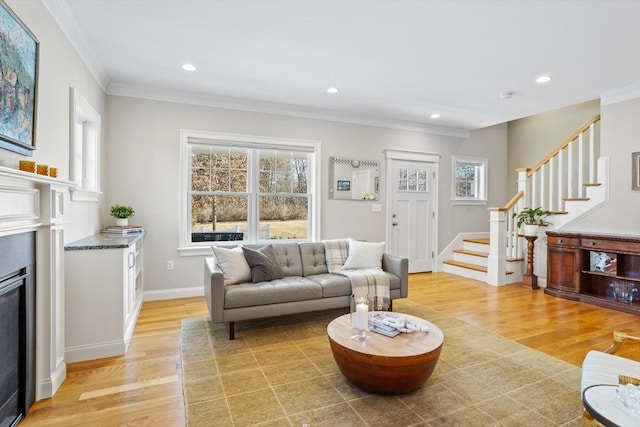 living area with a wealth of natural light, stairway, and light wood finished floors