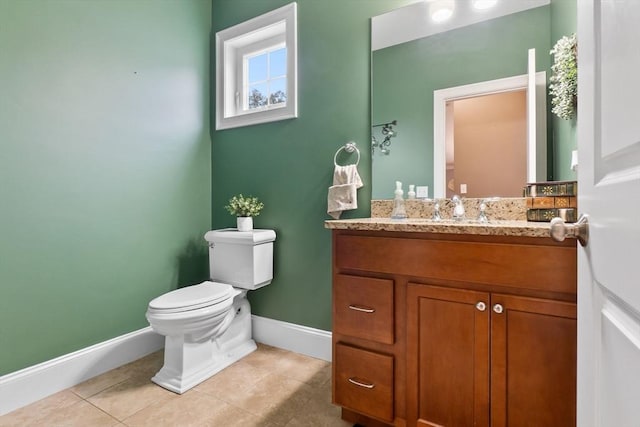 bathroom with baseboards, tile patterned flooring, vanity, and toilet