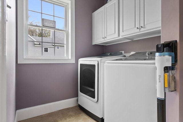 clothes washing area with baseboards, independent washer and dryer, light tile patterned floors, and cabinet space