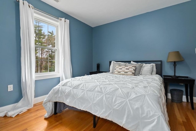 bedroom with baseboards and wood finished floors