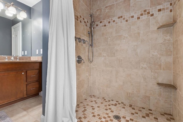 full bathroom with a tile shower and vanity