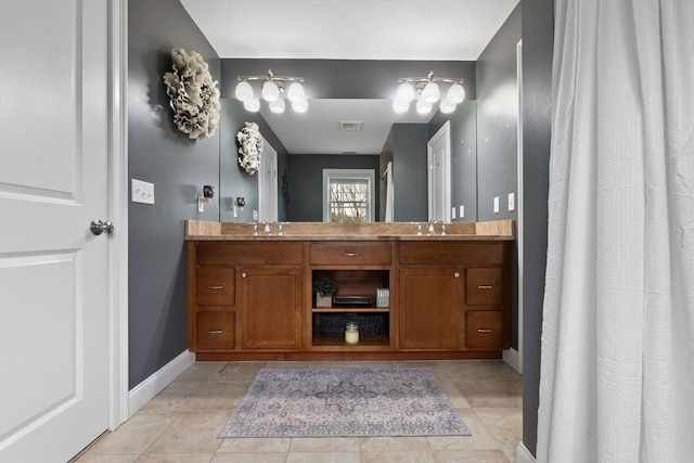bathroom featuring baseboards, visible vents, a sink, and double vanity
