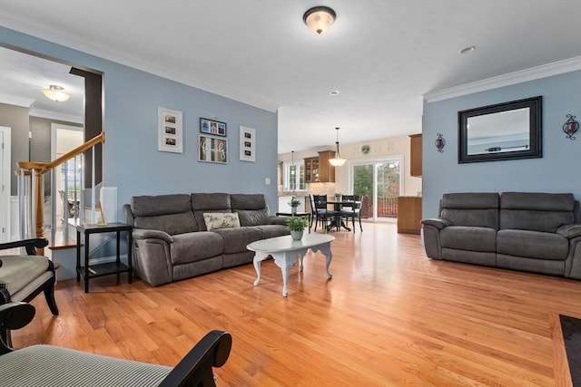 living area featuring light wood-style floors and crown molding