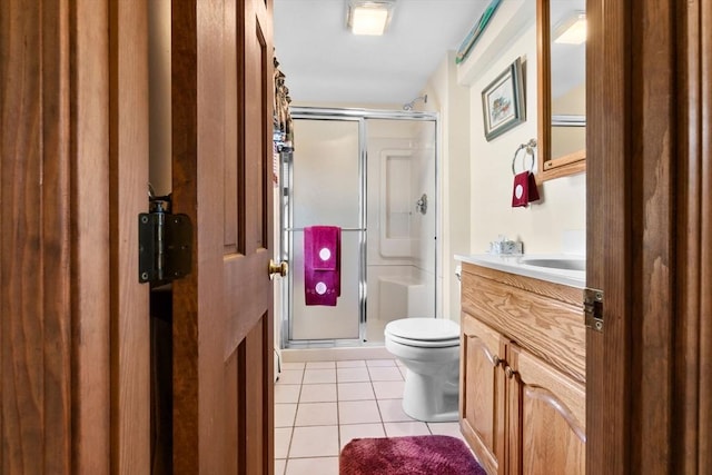 bathroom with tile patterned floors, vanity, a stall shower, and toilet