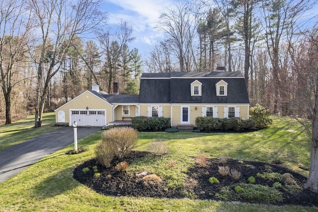 colonial inspired home with driveway, a chimney, a front yard, and a garage