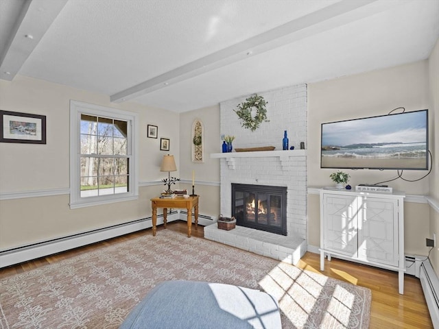 living room featuring a brick fireplace, beam ceiling, a baseboard heating unit, and wood finished floors