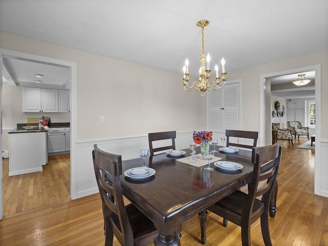 dining area featuring light wood-type flooring and a notable chandelier
