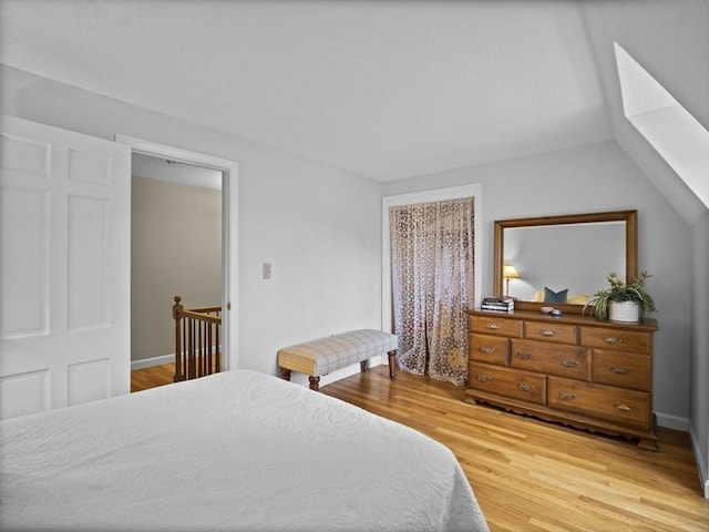 bedroom featuring light wood-style flooring and lofted ceiling