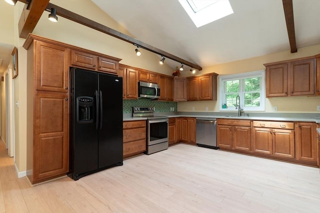 300 Henshaw St, Leicester, MA 01524 - kitchen featuring appliances with stainless steel finishes, a skylight, light wood finished floors, and brown cabinets