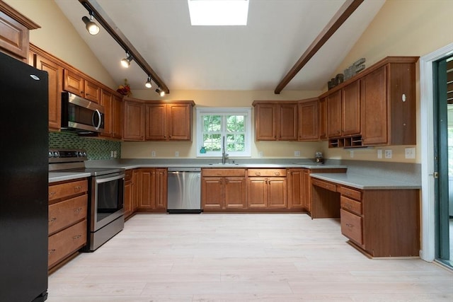 300 Henshaw St, Leicester, MA 01524 - kitchen featuring appliances with stainless steel finishes, track lighting, vaulted ceiling, light wood-style floors, and brown cabinets