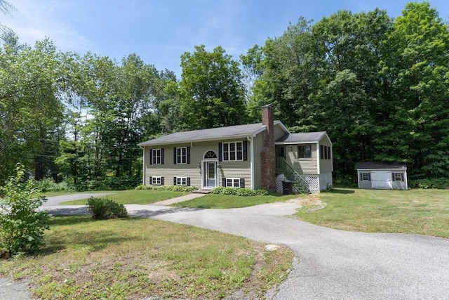 300 Henshaw St, Leicester, MA 01524 - split foyer home with a shed, a chimney, a front yard, and view of wooded area