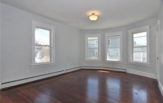 unfurnished room featuring a baseboard heating unit, baseboards, a healthy amount of sunlight, and wood finished floors