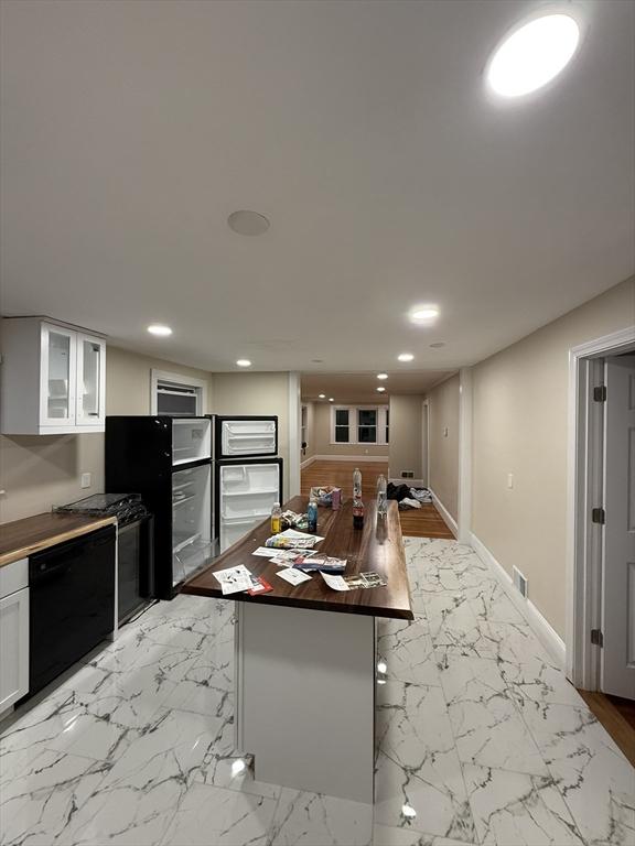 9-11 Elson Rd, Waltham, MA 02451 - kitchen featuring dishwasher, white cabinetry, glass insert cabinets, recessed lighting, and light marble finish floors