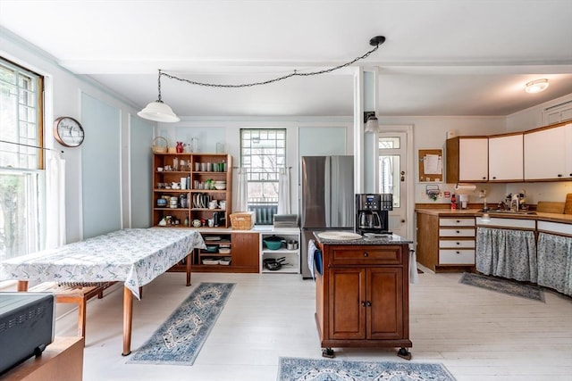 26 S Main St, Belchertown, MA 01007 - kitchen featuring light wood-style floors, dark stone counters, freestanding refrigerator, pendant lighting, and brown cabinets