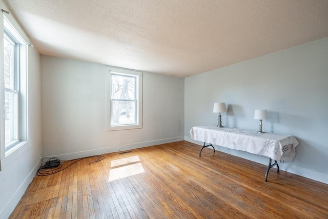 26 S Main St, Belchertown, MA 01007 - unfurnished bedroom with wood-type flooring, baseboards, visible vents, and a textured ceiling