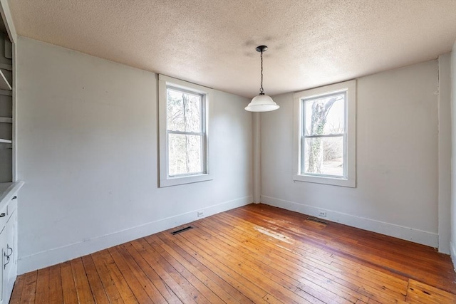 26 S Main St, Belchertown, MA 01007 - unfurnished dining area with plenty of natural light, light wood finished floors, visible vents, and baseboards