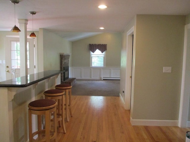 4 Deepwater Ln, Walpole, MA 02091 - kitchen with a breakfast bar area, baseboard heating, light wood finished floors, dark countertops, and hanging light fixtures