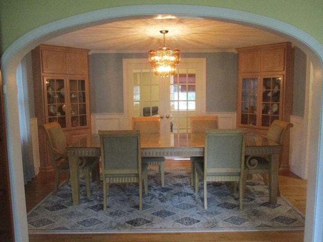 4 Deepwater Ln, Walpole, MA 02091 - dining space featuring arched walkways, a decorative wall, a chandelier, a wainscoted wall, and wood finished floors