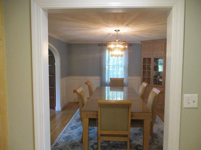 4 Deepwater Ln, Walpole, MA 02091 - dining room with arched walkways, a chandelier, wood finished floors, a decorative wall, and a wainscoted wall