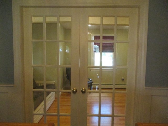 4 Deepwater Ln, Walpole, MA 02091 - detailed view of french doors, wood finished floors, and a baseboard heating unit