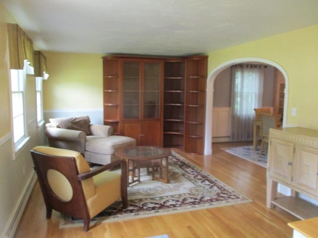 4 Deepwater Ln, Walpole, MA 02091 - living area featuring arched walkways, healthy amount of natural light, light wood-style floors, and a wainscoted wall